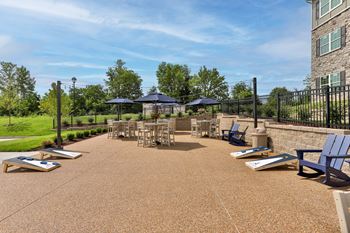 community patio with grills, chairs and umbrellas  at Aventura at Hawk Ridge, Missouri, 63367